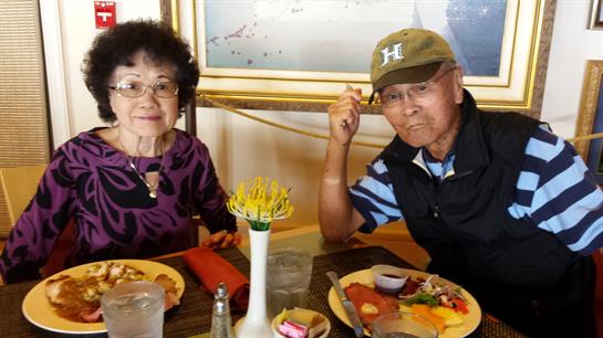 Senior couple enjoys a meal together in a bright restaurant, savoring good food and company.