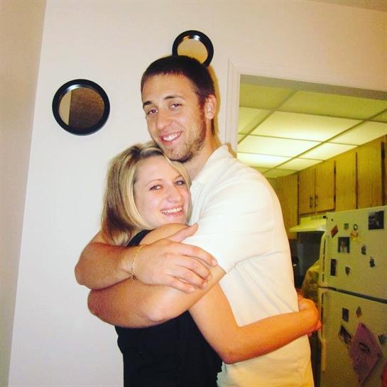 Friends enjoy a joyful moment together, hugging in a casual indoor environment filled with warmth.