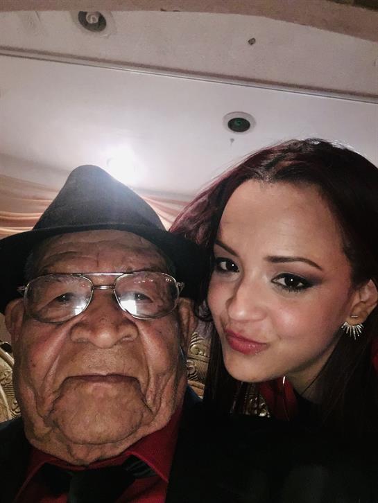 A touching moment captures a grandfather and granddaughter smiling and enjoying a family gathering.