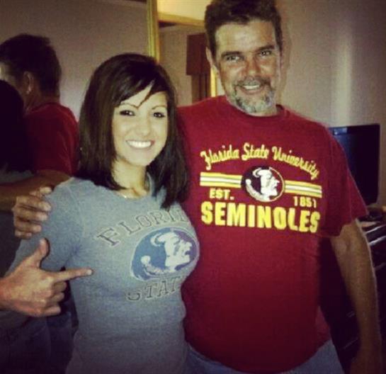 Individuals share a joyful moment while wearing team shirts in a cozy environment.