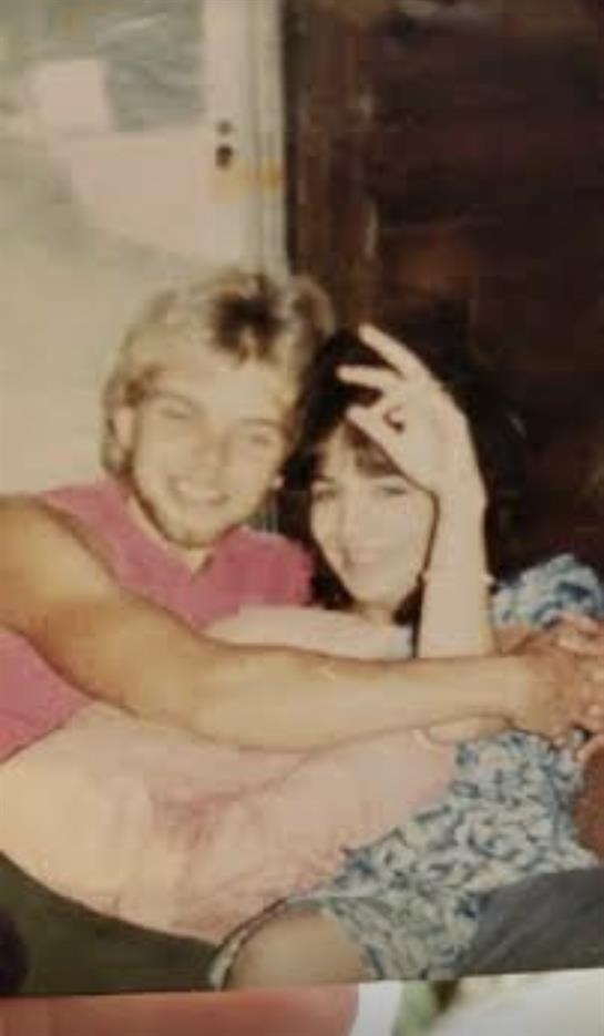 Happy couple embraces each other while sharing a joyful moment in their home.