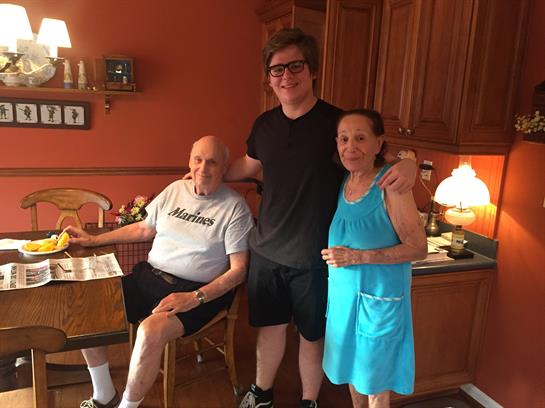 Three family members share smiles and laughter in a warm kitchen setting during a summer afternoon.