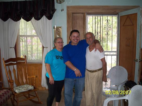 Three family members share a warm embrace in a bright, welcoming room filled with light.