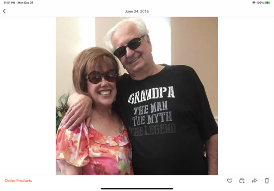 A happy couple poses together, embracing each other with smiles in a bright setting.