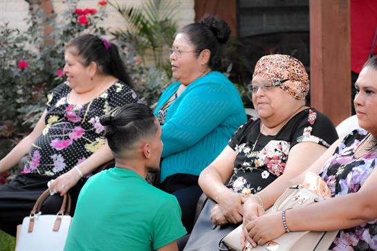 Groups of people engage in lively conversation and enjoy each other's company outdoors.