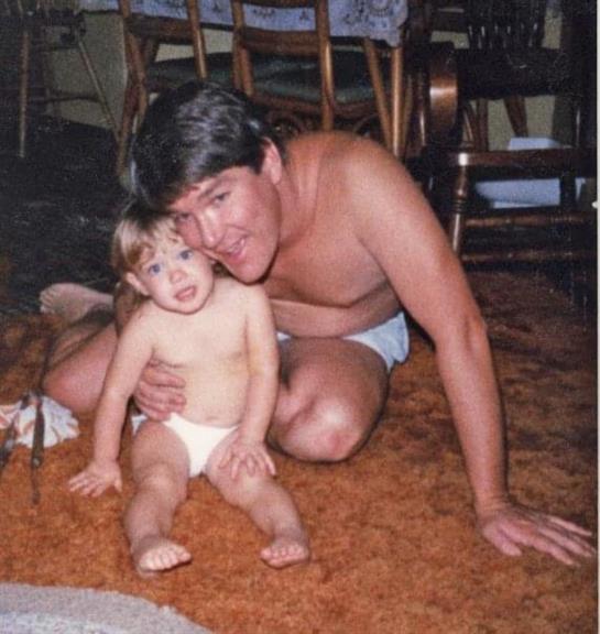 A father and his young child enjoy a playful moment together in a cozy indoor setting.