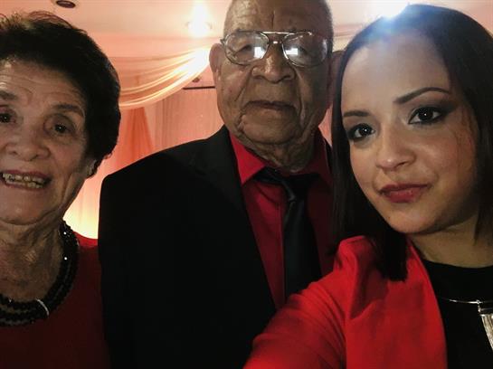 Three family members in red radiate warmth and happiness at the celebration.