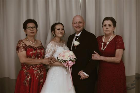 Guests gather to celebrate a joyful wedding ceremony, dressed in elegant attire with smiles shared.