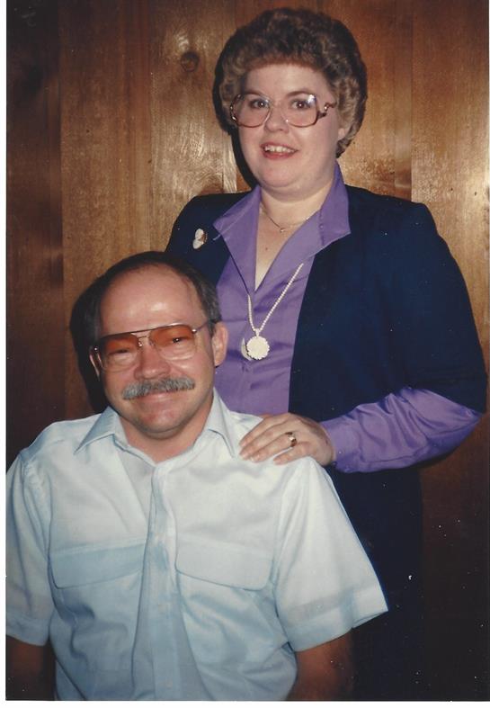 Two individuals smile warmly, showcasing joy and connection at a social event indoors.