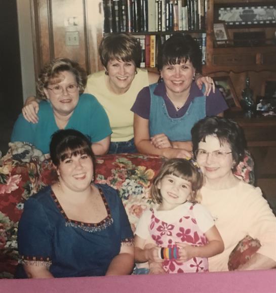 Group of seven family members sharing a joyful moment together in a cozy home setting.