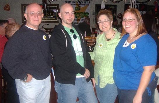 Several friends gather and smile at a social event, showcasing camaraderie in a relaxed atmosphere.