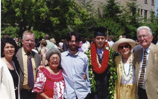 Group of family members joyfully celebrating a graduation ceremony with flowers and smiles.