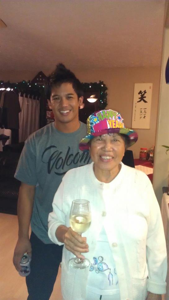 Two family members enjoy a joyful moment at home during a celebration, holding drinks.