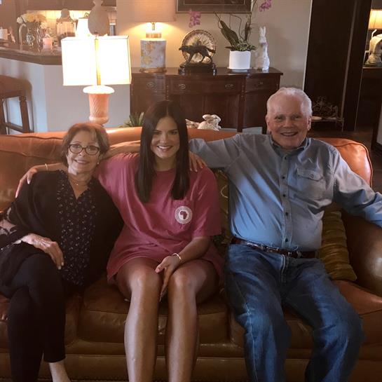 Three family members enjoy time together on a comfortable couch in a welcoming living room.