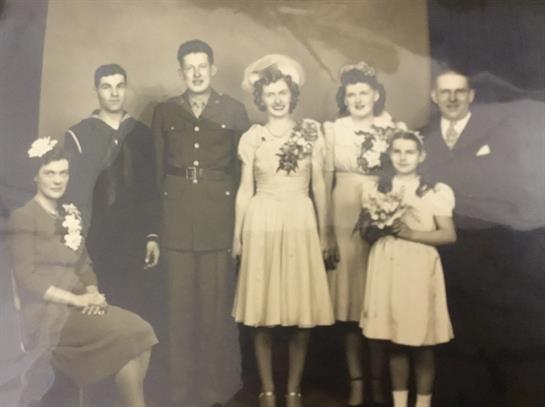 A nostalgic family portrait of elegantly dressed members celebrating together in a studio.