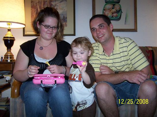A happy family enjoys time together as their child plays with a toy, filled with laughter and joy.