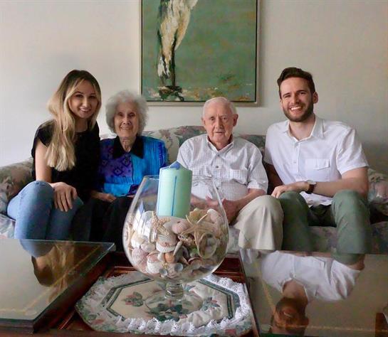 Four family members pose together in a comfortable living room, showcasing joy and connection.
