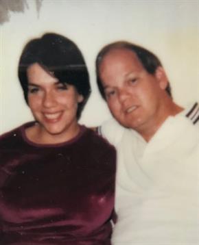 A couple smiles close together, enjoying a friendly vibe at a past gathering.