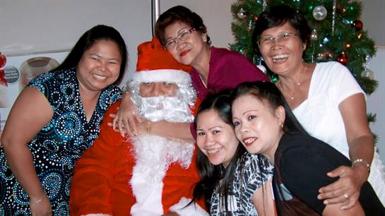 A group of women enjoy a festive moment with Santa, celebrating Christmas joyfully together.