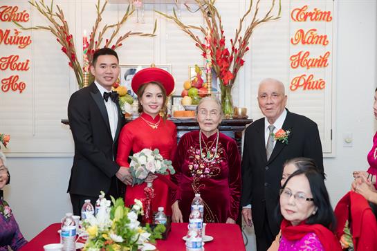 A joyful wedding captures the couple and family in cultural attire and decorations.
