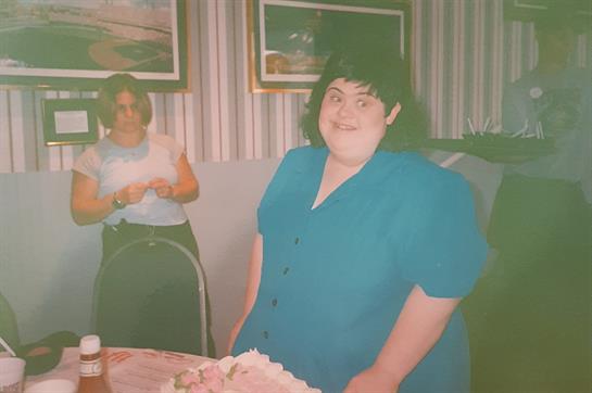 Friends gather to celebrate a birthday, smiling and enjoying cake in a cheerful atmosphere.