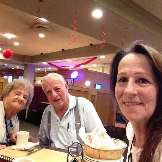 Three family members enjoy dessert together in a cheerful restaurant atmosphere.