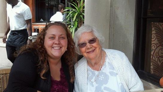 Two women share a joyful moment at a cafe, highlighting their strong bond and happiness.