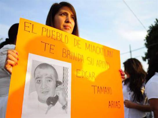Supporters rally in Miraflores for Edgar Tamas Arias, demanding justice with signs.