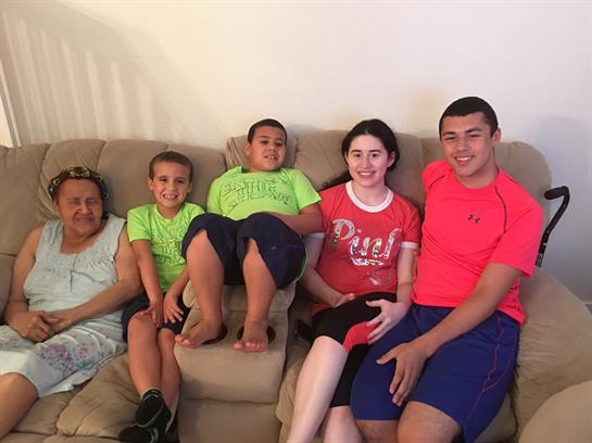 Family members share smiles and enjoy each other's company on the couch in their living room.