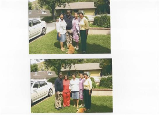 Family and friends pose together in a vibrant backyard with a playful dog nearby.