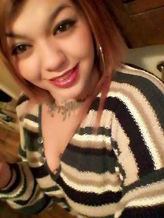 A young woman with red hair smiles warmly at the camera.