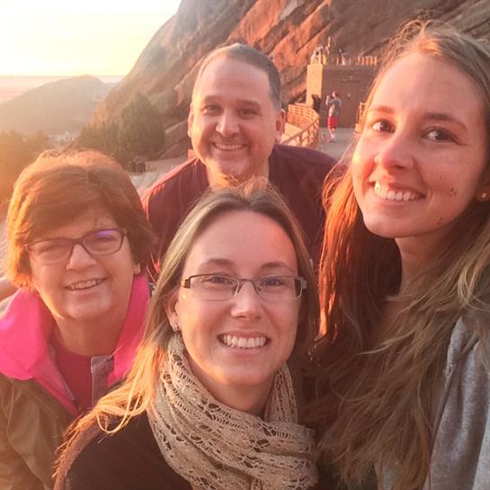 Four friends gather for a joyful moment at sunset, surrounded by stunning natural scenery.
