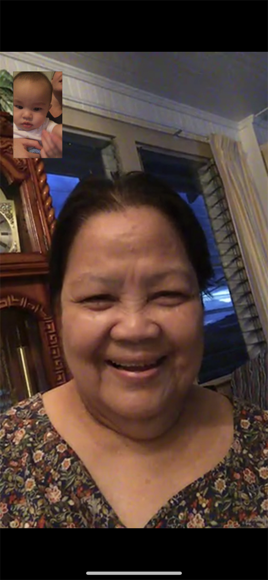 A smiling woman at home, surrounded by warm decor, creates a welcoming evening vibe.