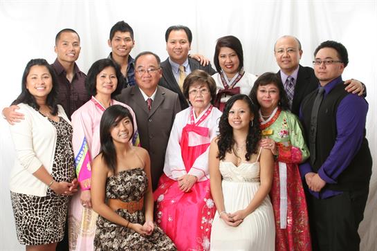 Group of family members posing together, wearing traditional costumes, smiling and celebrating.
