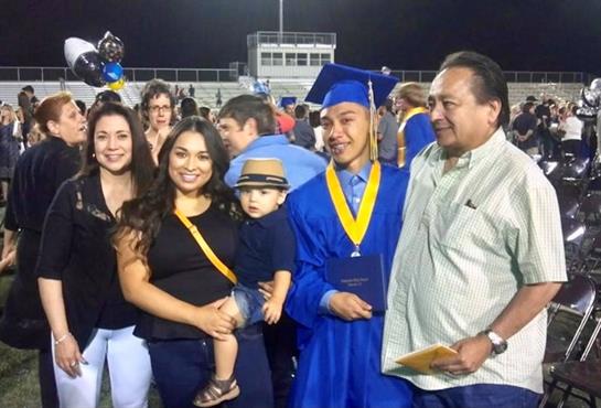 Family celebrates graduation with joy and pride during nighttime festivities.