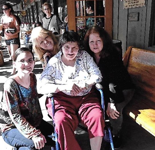 Four friends enjoy each other's company outdoors, laughing and posing for a memorable moment.