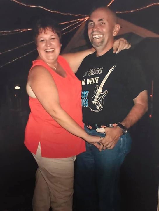 Two individuals happily dance together outdoors, enjoying a lively evening filled with laughter.