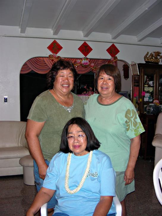 Three friends enjoy quality time together in a warmly decorated living room.