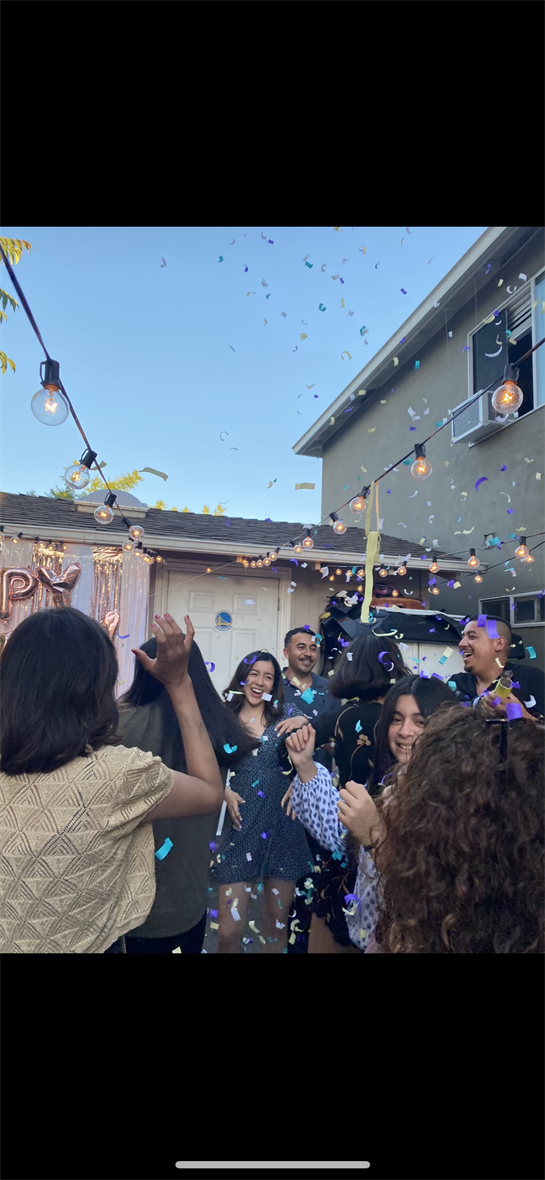 A joyful evening in the backyard, with laughter and confetti under string lights.