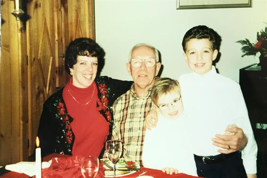 A joyful dinner gathering with grandparents and grandchildren enjoying time together.