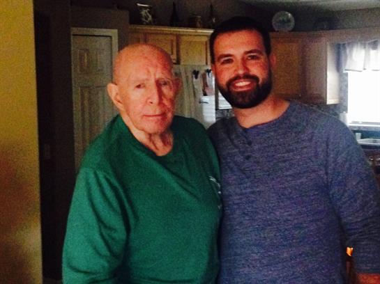 Two men stand close together in a warm kitchen, showcasing their family connection and joy.