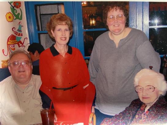 Four friends gathered around a table, sharing laughter and food, enjoying a relaxed evening.