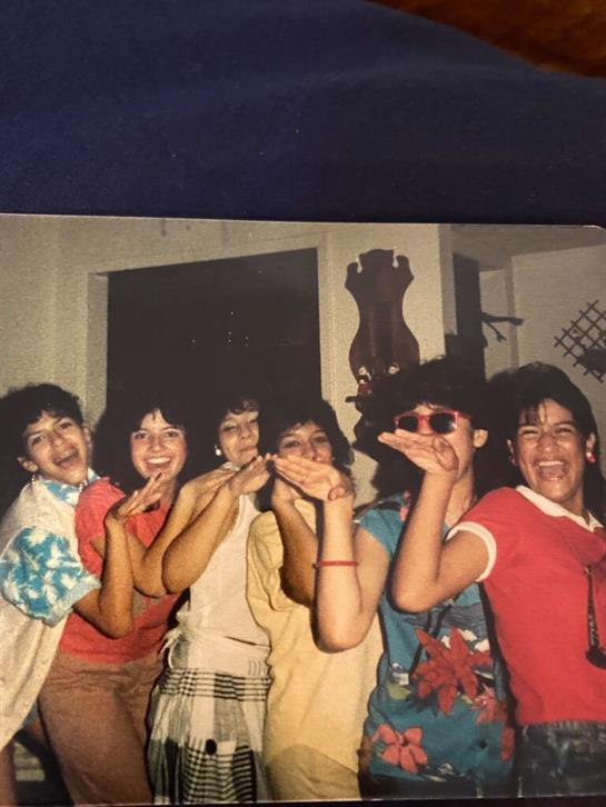 Friends gather in a playful atmosphere, striking poses and laughing during a lively home event.