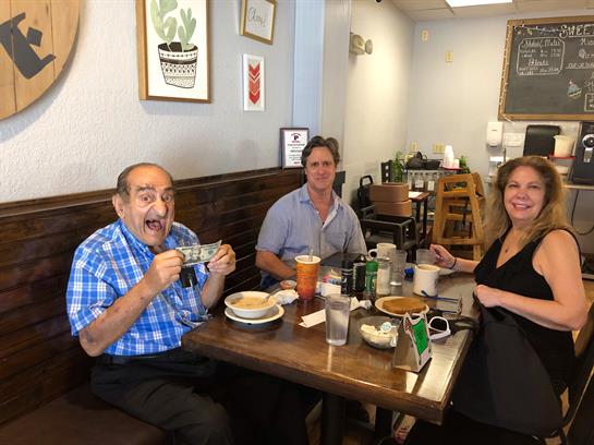 Friends share laughter and conversation while dining at a local eatery in the afternoon.