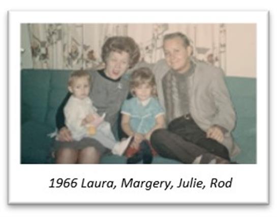A family enjoys time together on a green couch, smiling happily in a home setting.