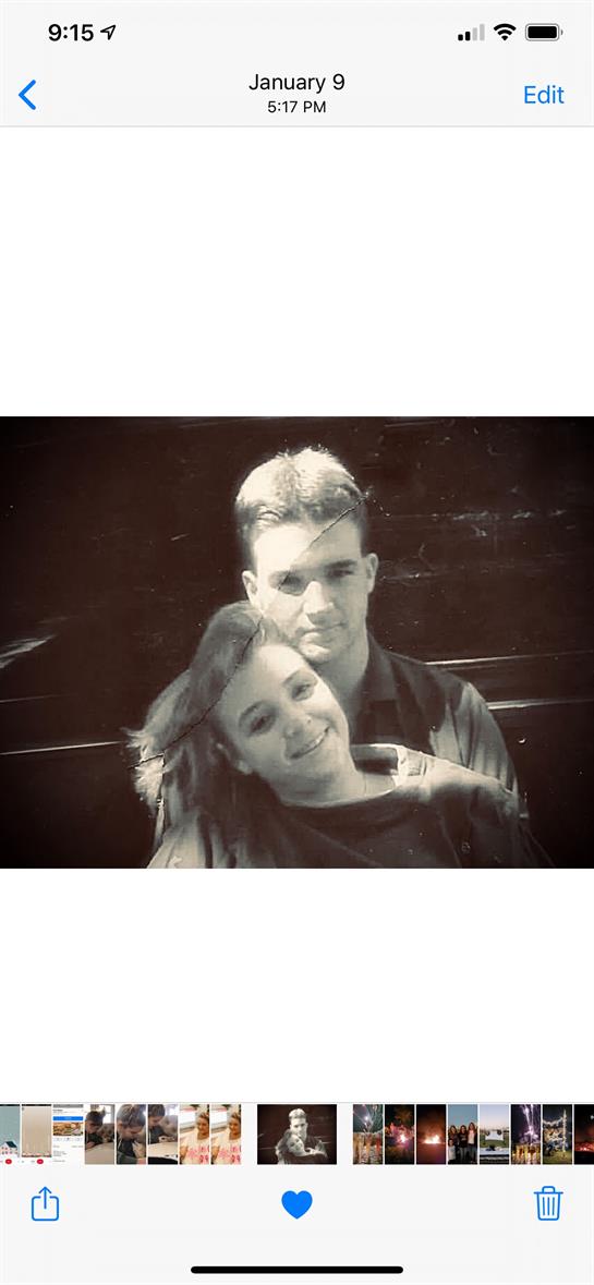 Two young people share a moment of happiness outdoors, enjoying a sunny day in a park.