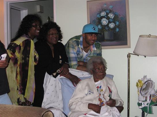Four family members enjoy a warm moment together, smiling and sharing stories in a cozy living area.