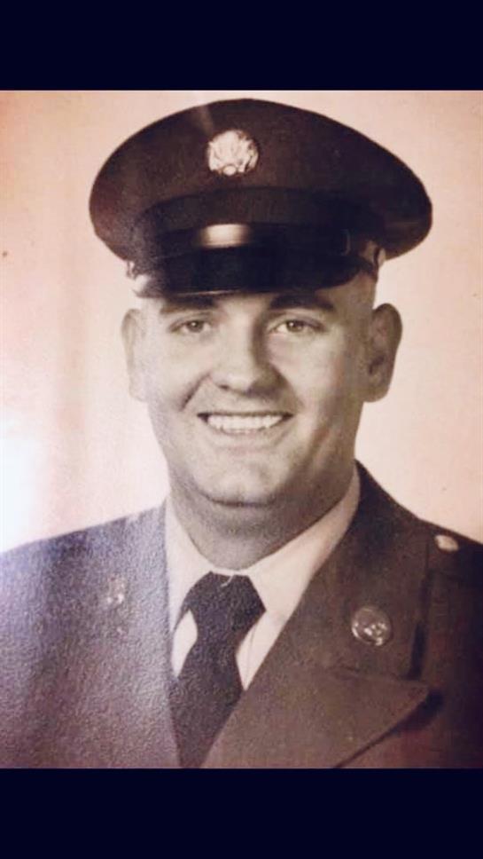 A soldier in military uniform smiles confidently, capturing a moment of pride and service.