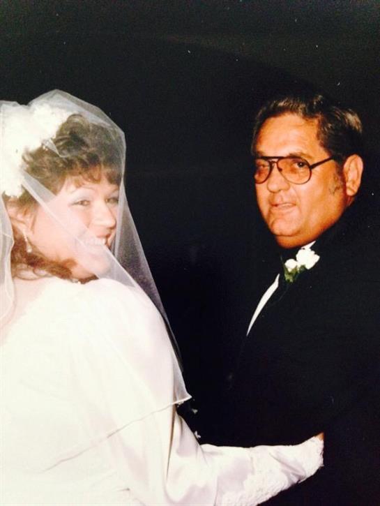 A joyful couple shares a moment during their wedding ceremony, dressed in formal attire and a veil.
