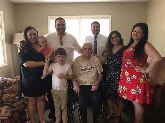 Family members of all ages joyfully celebrate a special occasion in a cozy living room.